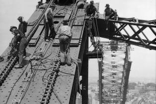 Workmen on incomplete north side of arch.